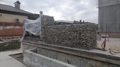 Мангал из сварного габиона на участке, обложенный натуральным камнем.